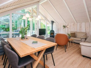 Une pièce spacieuse avec une table à manger en bois, des chaises, un canapé et une cheminée.