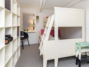 A child's bedroom with a bunk bed, a desk, shelves, a chair, and a window with a lamp. - 12 Person Holiday Home in Thisted (Frøstrup)