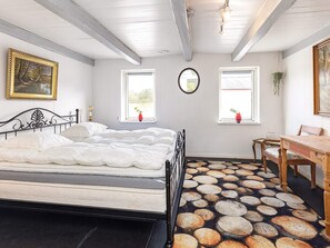 A bedroom with a bed, two windows, a mirror, a wooden table, and a chair. - 12 Person Holiday Home in Thisted (Frøstrup)