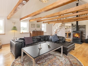 A modern living room with a leather sofa, a coffee table, and a fireplace.