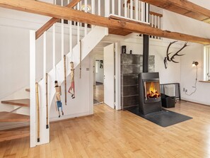 Un interior moderno con una escalera de madera, una chimenea y decoración con cuernos de ciervo.