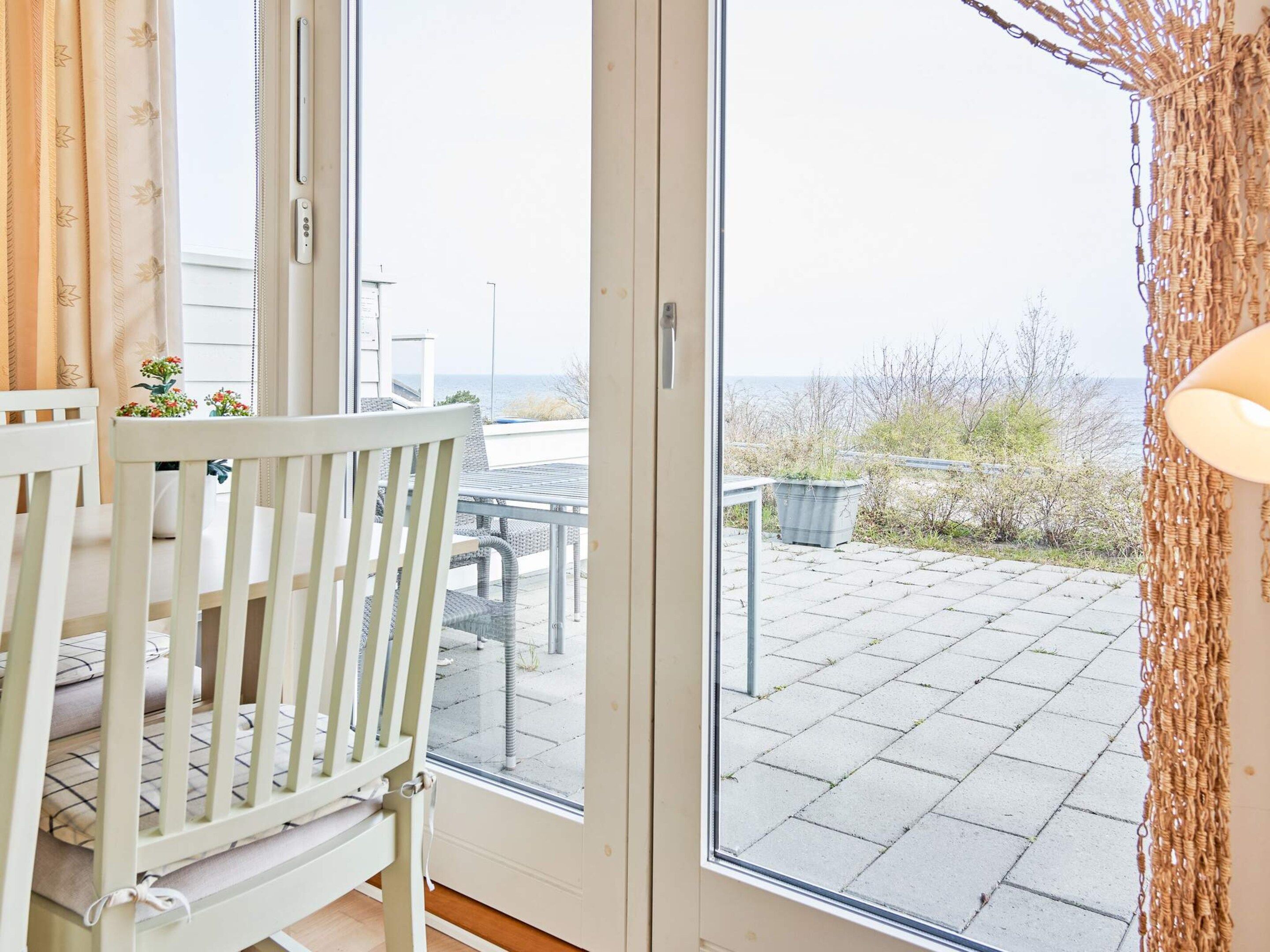 Una habitación con una cuna blanca, vistas al patio exterior y una puerta que da al balcón.