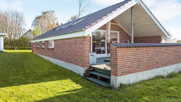 A brick building with a pitched roof and a covered porch.
