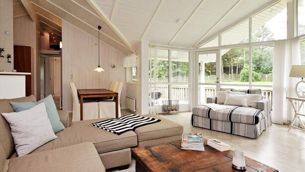 Tilava olohuone, jossa on suuri ikkuna, puinen sohvapöytä ja raidallinen sohva.