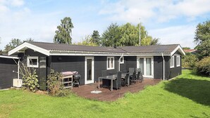 A single-story mobile home with a patio area, a small deck, and a covered outdoor seating area. - 4 Star Holiday Home in Jaegerspris (Jægerspris)