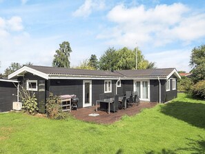 A single-story mobile home with a patio area, a small deck, and a covered outdoor seating area.