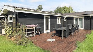 Ein Wohnmobil mit einer Terrasse, Sitzgelegenheiten im Freien und einem Grill.