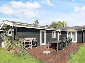 Una casa móvil con terraza, mobiliario exterior y una parrilla de barbacoa.