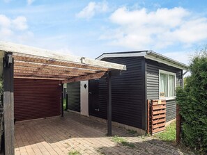 A two-story building with a covered patio area and a garage. - 4 Star Holiday Home in Jaegerspris (Jægerspris)