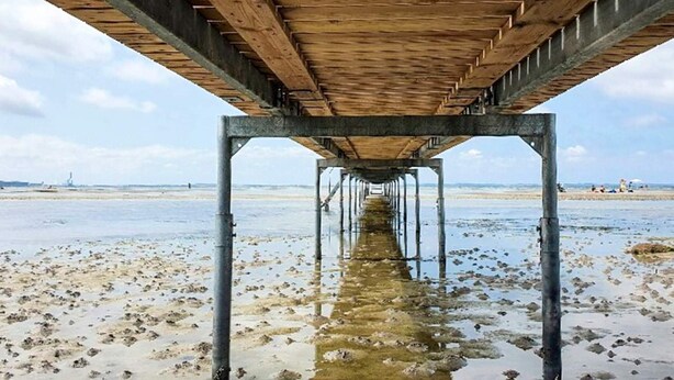 A wooden pier structure with metal supports extending into a beach. - 4 Star Holiday Home in Jaegerspris (Jægerspris)