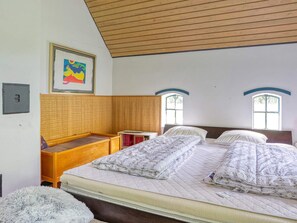 A bedroom with a bed, a wooden bench, a small table, and a window. - 9 Person Holiday Home in Vig (Vig)