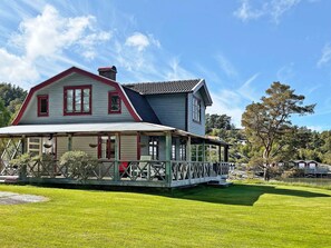 A two-story house with a porch, a chimney, and a small garden. - 4 Star Holiday Home in Uddevalla (Uddevalla)