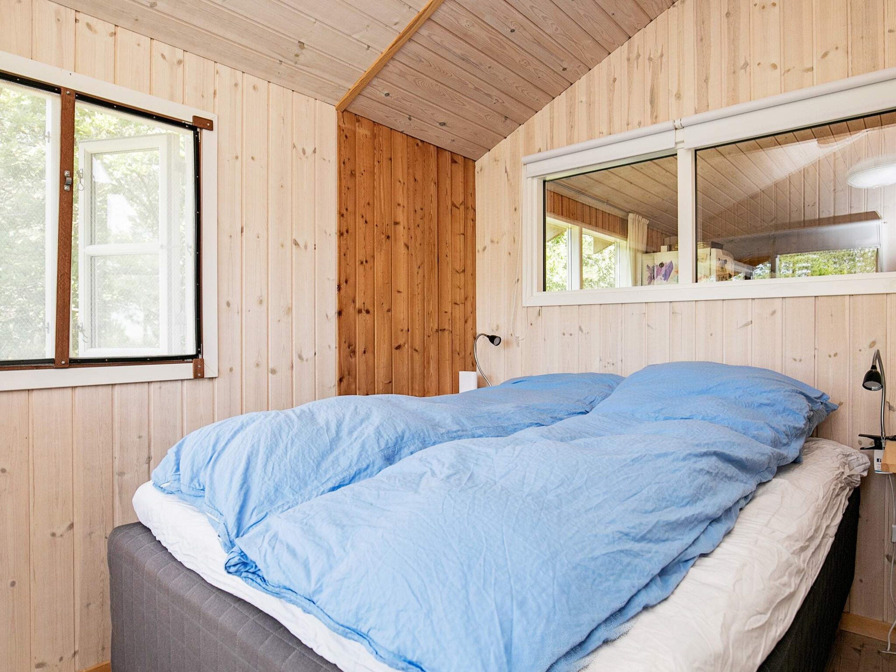 A room with a bed, a window, and a mirror.