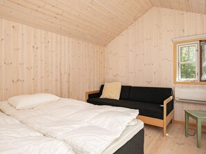 A room with a bed, a sofa, a window, and an air conditioning unit. - 12 Person Holiday Home in Laeso (Læsø)