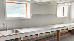 A kitchen with a large countertop, two windows, and visible plumbing. - 8 Person Holiday Home in Snillfjord (Orkland)