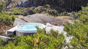 A hot tub surrounded by rocks and pine trees. - 4 Star Holiday Home in Sondeled (Risør)