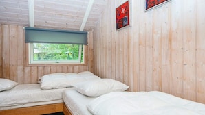A room with three beds, wooden walls, a window with a view of greenery, and a red artwork on the wall. - 6 Person Holiday Home in Ansager (Ansager)
