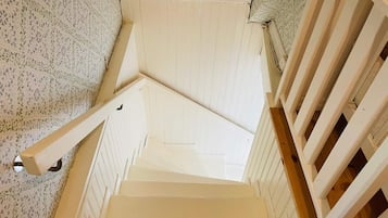 A staircase with white railings and a patterned wall.
