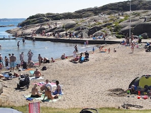 A beach scene with people sunbathing, swimming, and playing. - 4 Person Holiday Home in Lysekil (Lysekil)