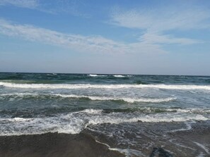 Una playa con olas y cielo despejado.
