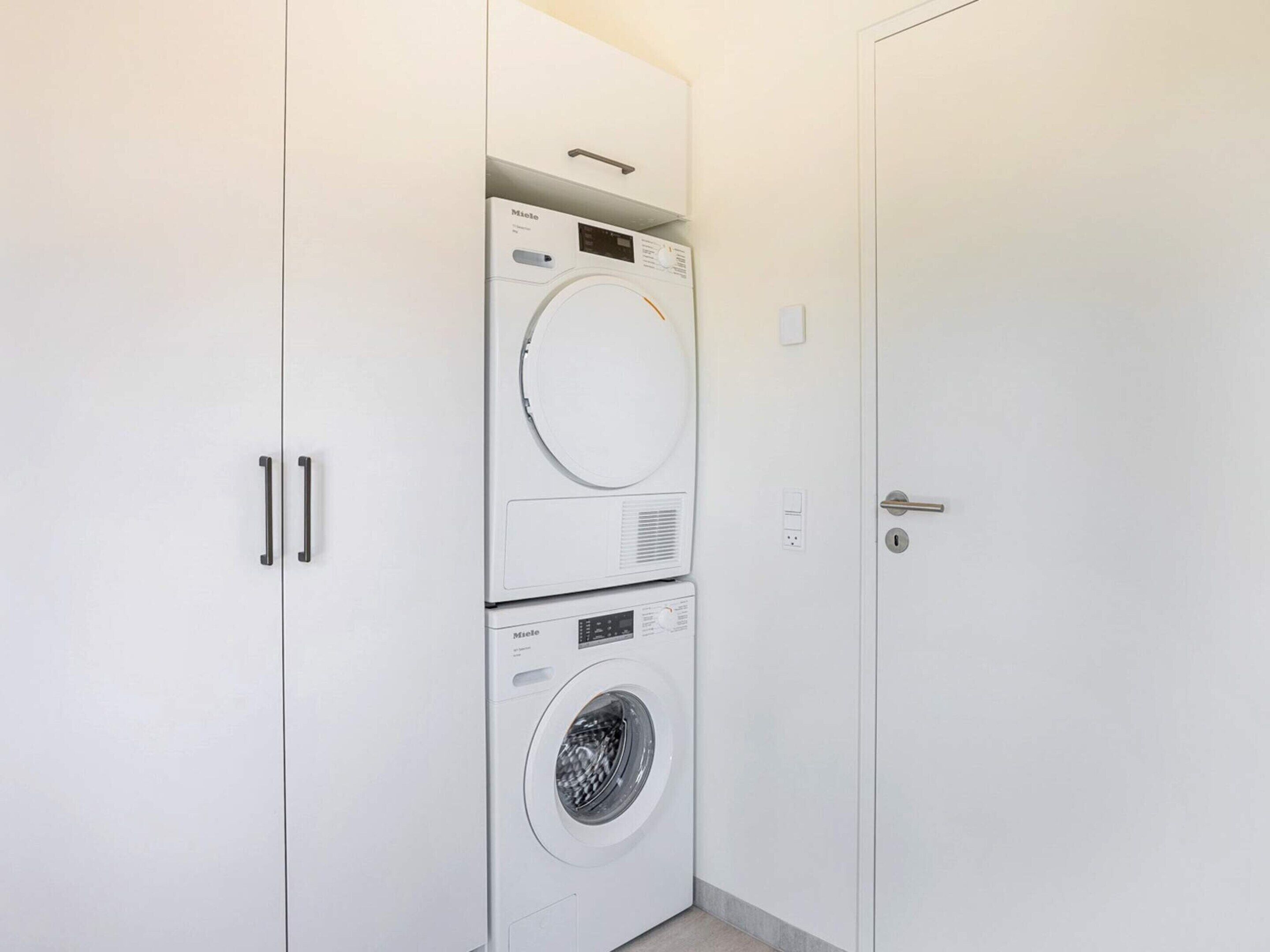 A laundry room with a top-loading washer and a front-loading dryer.