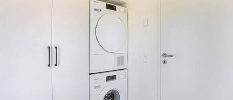 A laundry room with a top-loading washer and a front-loading dryer.