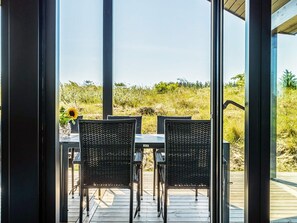 An outdoor seating area with two chairs and a table, overlooking a natural landscape. - 5 Star Holiday Home in Hirtshals (Hirtshals)