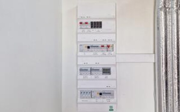 A control panel with various buttons and indicators, likely for room amenities or utilities.