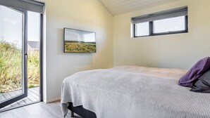 A bedroom with a bed, a window, and a view of a landscape. - 5 Star Holiday Home in Hirtshals (Hirtshals)
