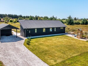 A modern house with a large lawn, a doghouse, and a playground. - 5 Star Holiday Home in Hirtshals (Hirtshals)