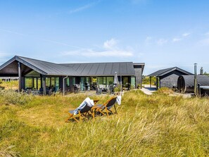 A modern building with a covered outdoor area, including seating and a grill.