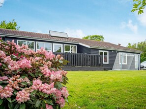 A residential building with a sloped roof, a visible window, and a fenced yard. - 6 Person Holiday Home in Struer (Struer)