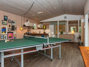A room with a ping pong table, wooden walls, and various framed artworks. - 6 Person Holiday Home in Struer (Struer)