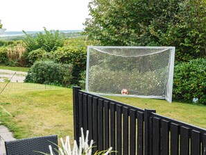 A soccer goal in a backyard with a wooden fence and greenery. - 6 Person Holiday Home in Struer (Struer)