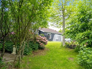 A residential property with a well-maintained lawn, a wooden fence, and a house with a tiled roof. - 6 Person Holiday Home in Struer (Struer)