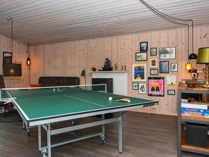 A ping pong table in a room with wooden walls and a fireplace. - 6 Person Holiday Home in Struer (Struer)