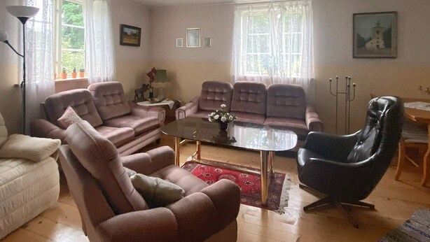 A living room with a sofa set, a coffee table, and a black armchair. - 8 Person Holiday Home in Virestad (Virestad)