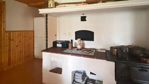 A compact kitchen with a refrigerator, a stove, and a small countertop with various items. - 8 Person Holiday Home in Virestad (Virestad)