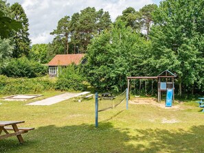 A playground with swings, slides, and picnic tables.