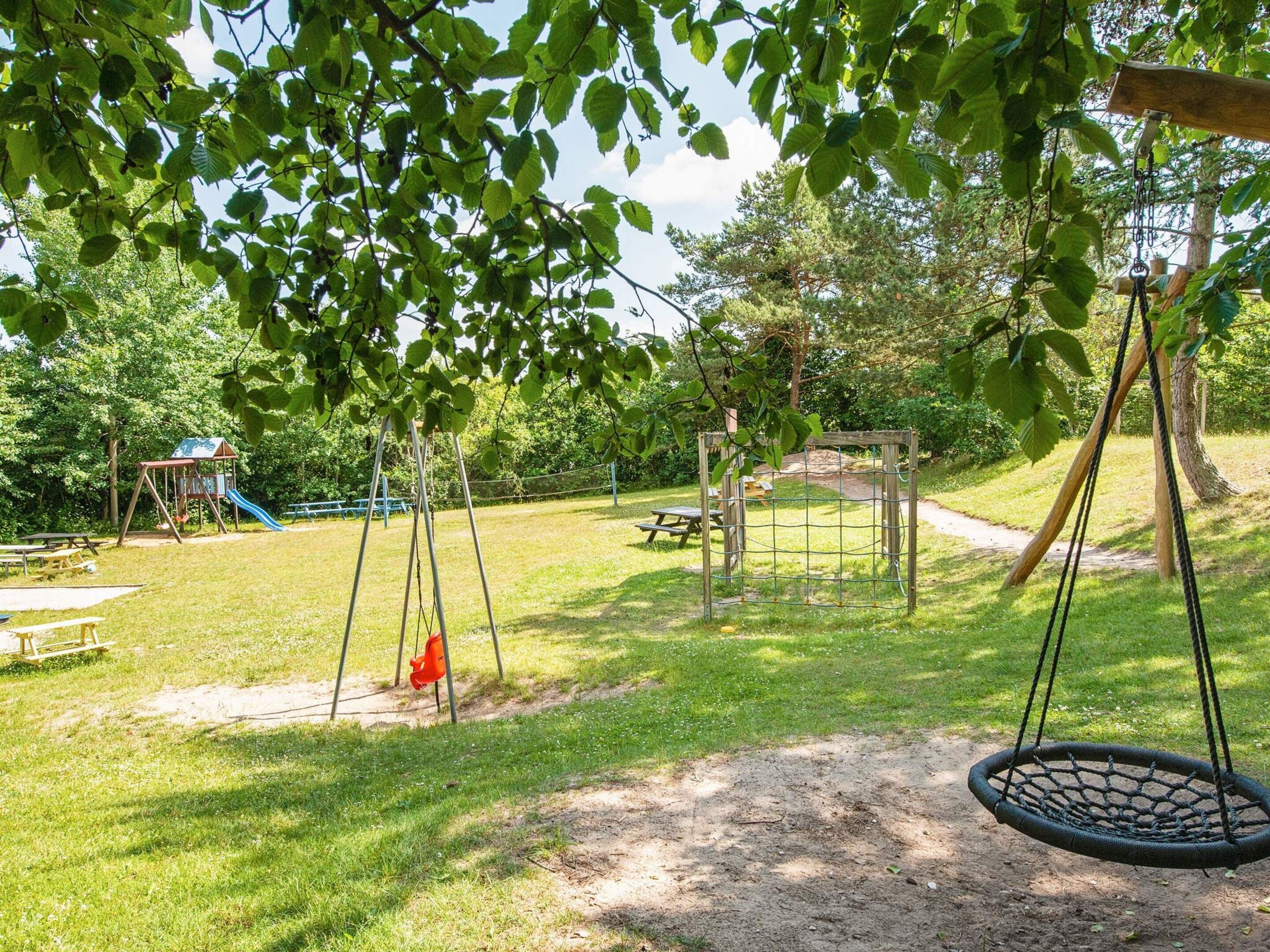 A playground with swings, a slide, and a picnic table.
