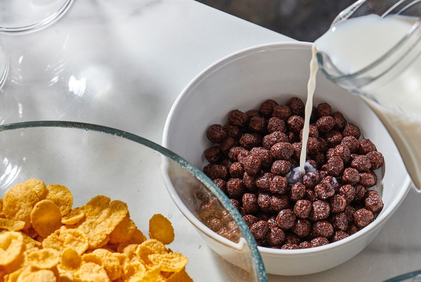 Un tazón de cereal con leche siendo servida.