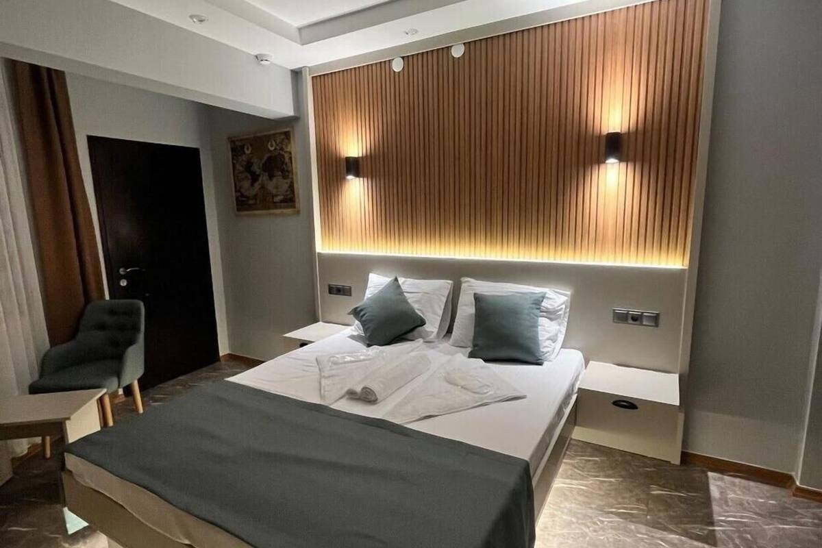 Una habitación de hotel moderna con una cama grande, un escritorio y una silla.