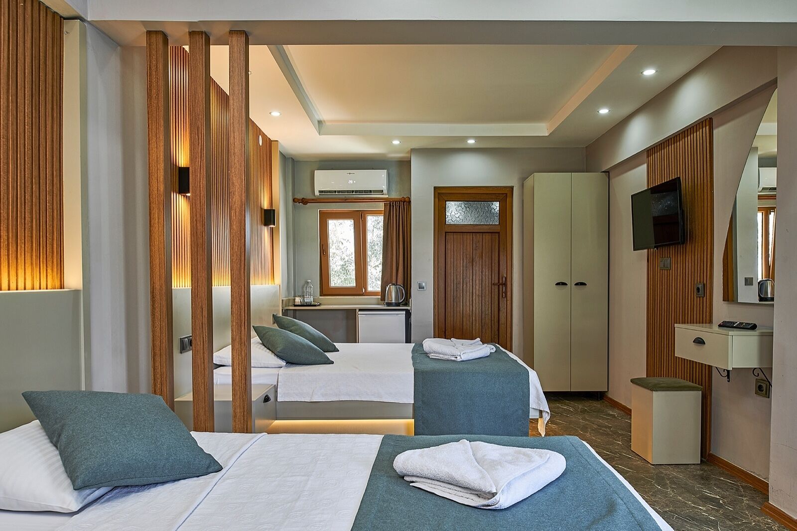 Habitación de hotel con dos camas, un escritorio, un televisor y un baño.