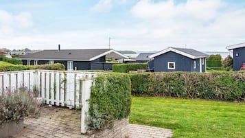 A residential area with multiple houses, a paved driveway, and a well-maintained lawn.