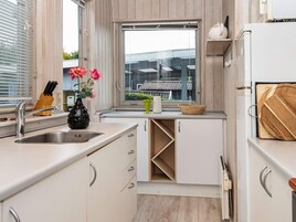 Cocina moderna con un lavabo, una ventana y vistas a un edificio.