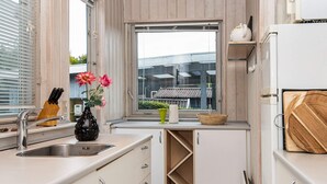 Cuina moderna amb un rentatge, una finestra i vista a edificis a l'exterior.