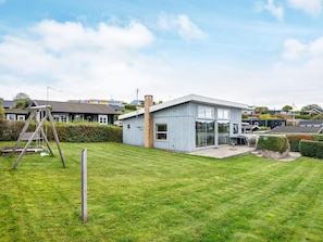 A modern house with a large glass window, a brick chimney, and a grassy yard. - 4 Person Holiday Home in Ronde (Ronde)