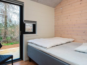 A bedroom with a bed, a window, and a view of trees. - 10 Person Holiday Home in Glesborg (Glesborg)