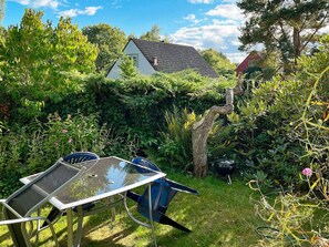 A garden with a table and chairs, a tree, and a house in the background. - 2 Person Holiday Home in Garsnas (Gärsnäs)