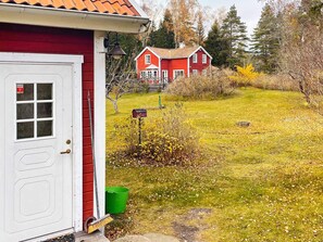 A red house with a white door, a mailbox, and a green bucket outside. - 5 Star Holiday Home in Bjorko (Björkö)